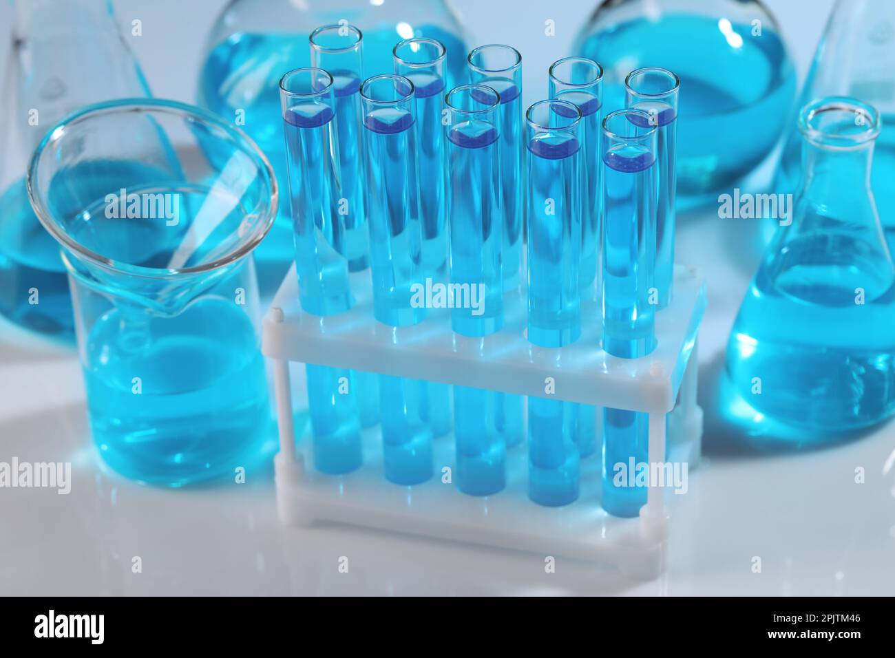 Laboratory glassware with blue liquid on light background Stock Photo ...