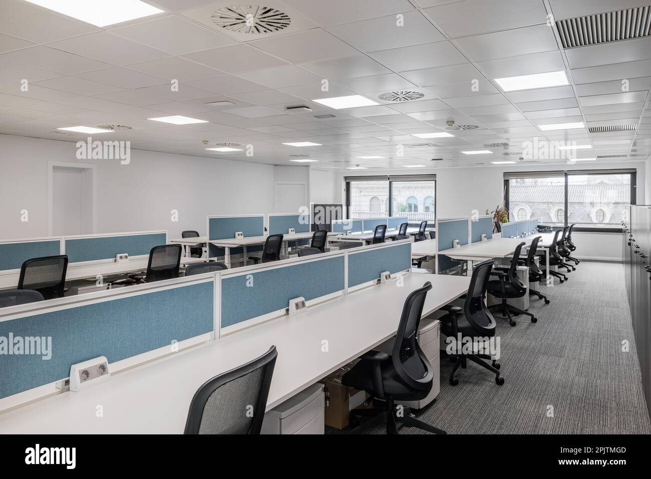 Empty office in gray tones with long tables and chairs for employees of ...