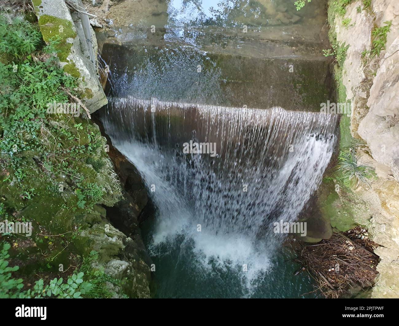 A majestic waterfall cascading down a craggy cliff face provides a ...