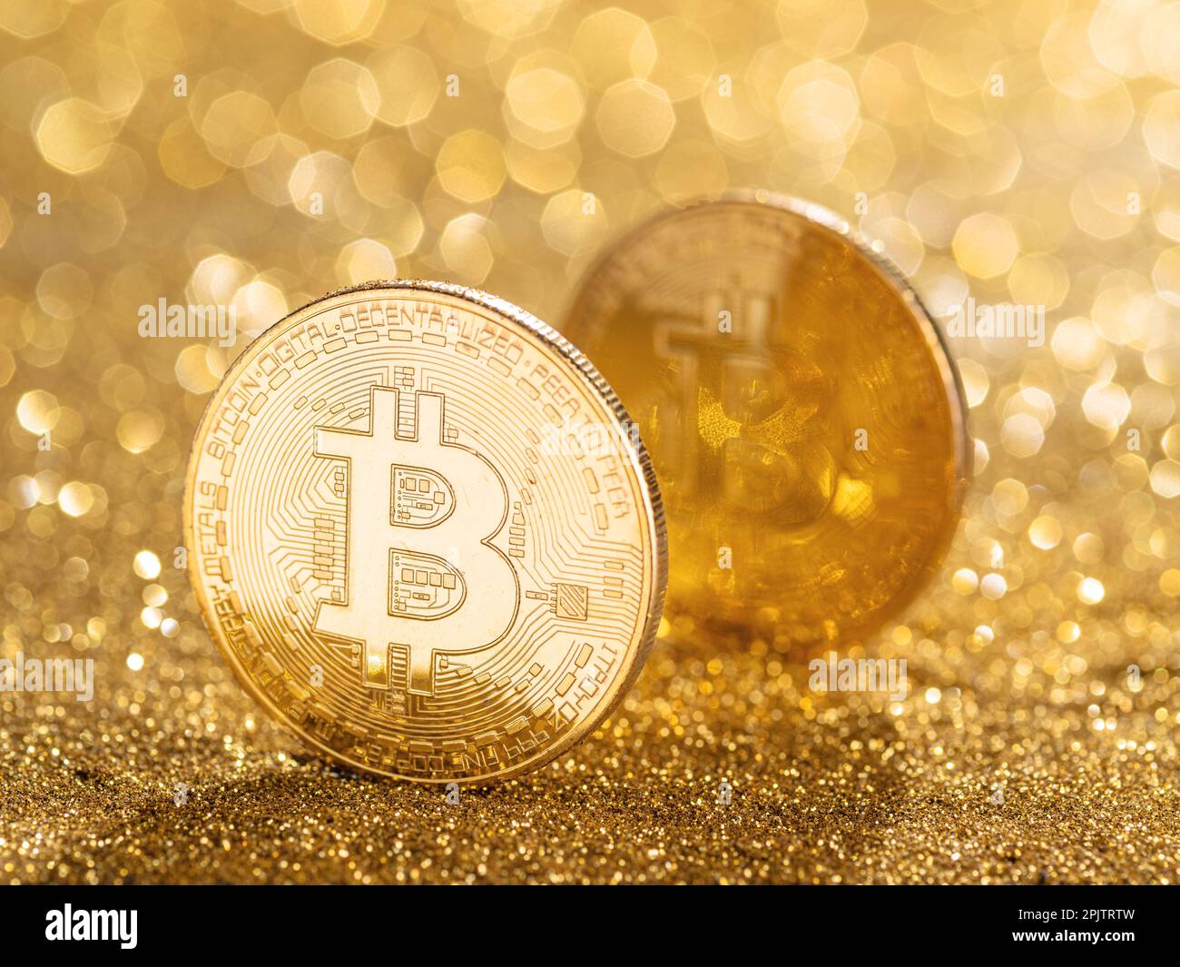 Gold bitcoin coin at the blazing gold background. Conceptual picture of digital money. Stock Photo