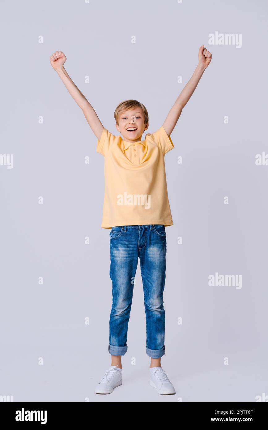 Happy boy Hands raised hands in happiness, wearing yellow t-shirt and ...