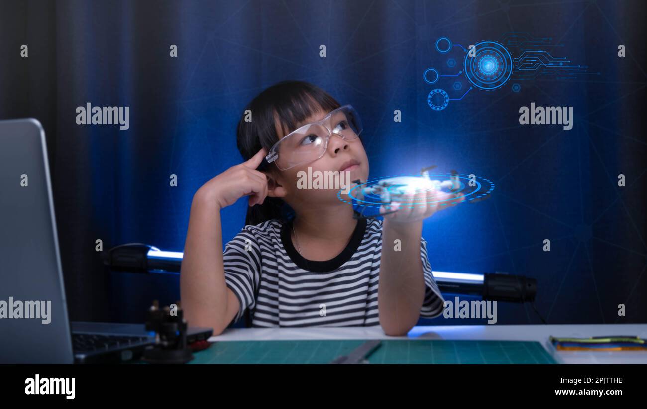 Child learning repairing getting lesson control toy drone in workshop, coding and solving engineering problem at home. Little Scientist School Project Stock Photo