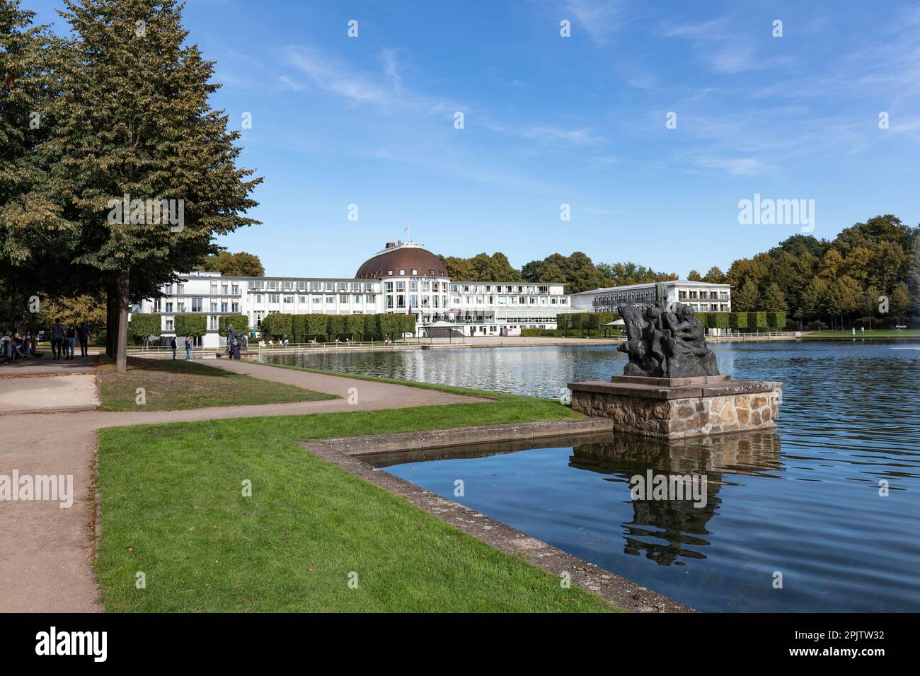Park Hotel by serene, peaceful Hollersee lake in Burgerpark with gardens, lakes, parkland. Four seasons Spring sculpture by Bernd Altenstein. Bremen. Stock Photo