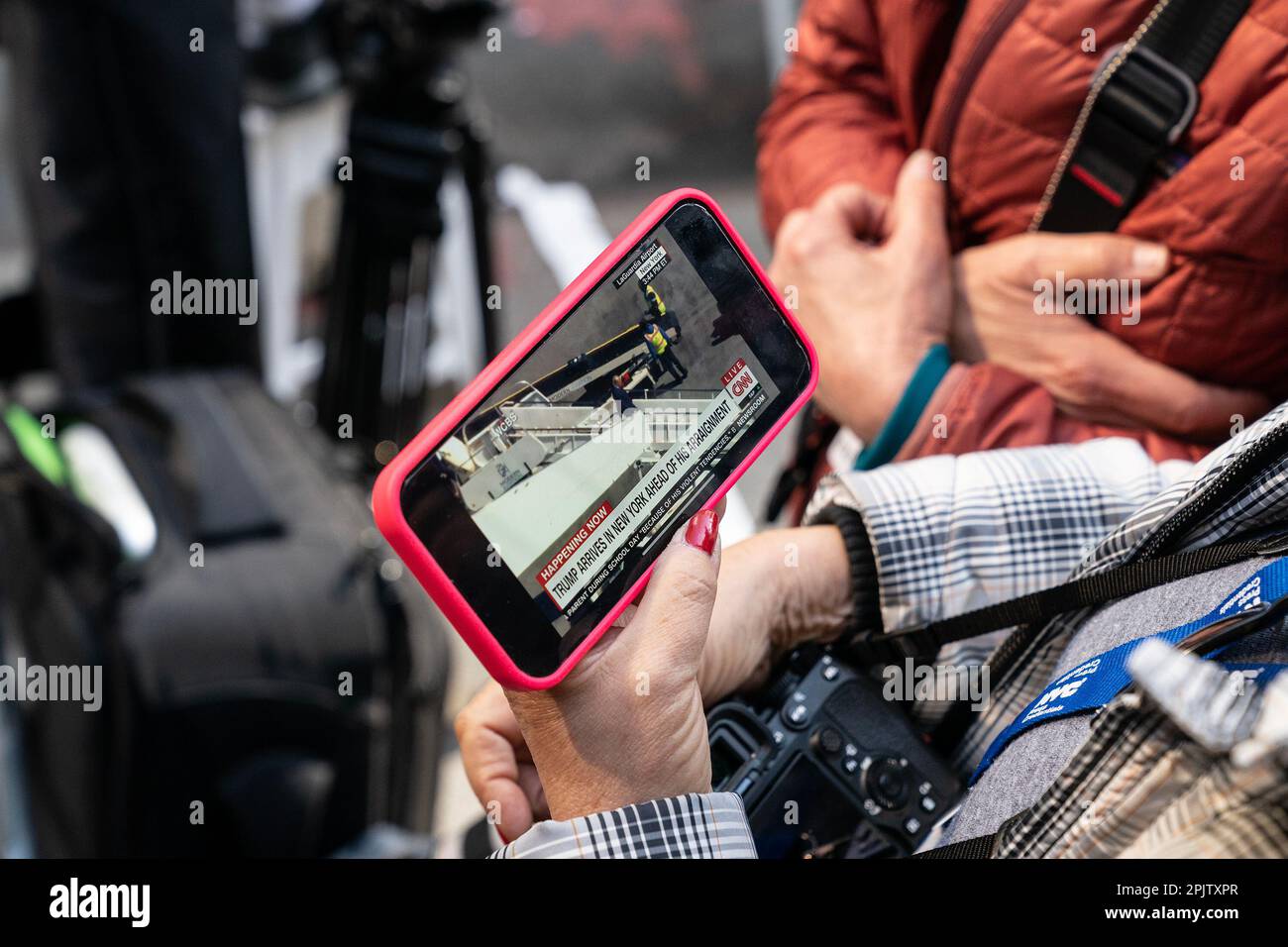 New York, New York, USA. 3rd Apr, 2023. A woman watches on cell phone CNN live report on President Donald Trump Jr. arriving in New York (Credit Image: © Photographer Lev Radin/Pacific Press via ZUMA Press Wire) EDITORIAL USAGE ONLY! Not for Commercial USAGE! Stock Photo