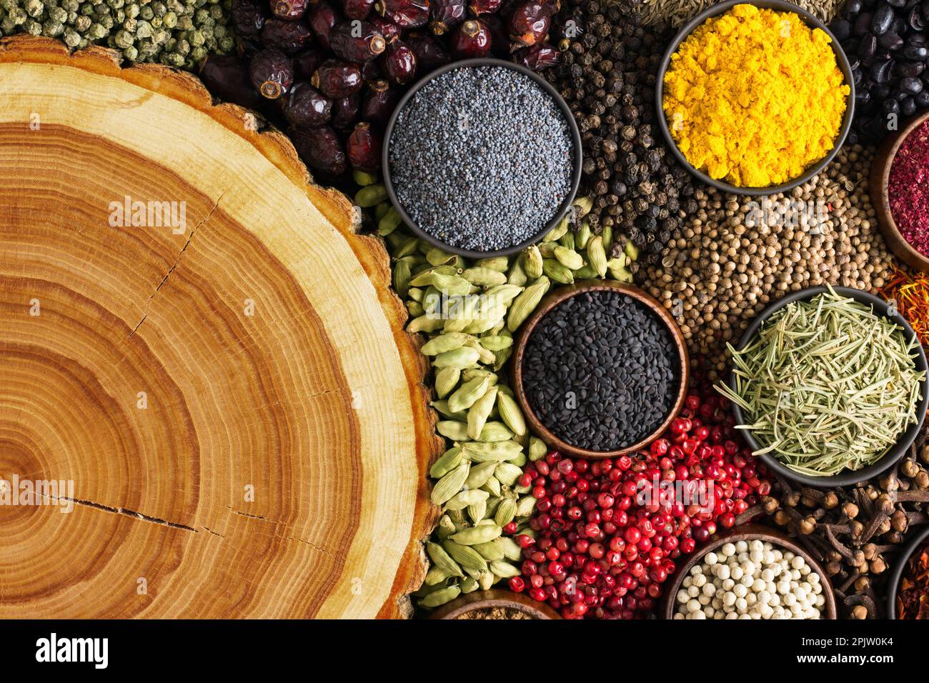 Condiments  scattered on table with empty space for text or label. Colorful spices and herbs background. Stock Photo