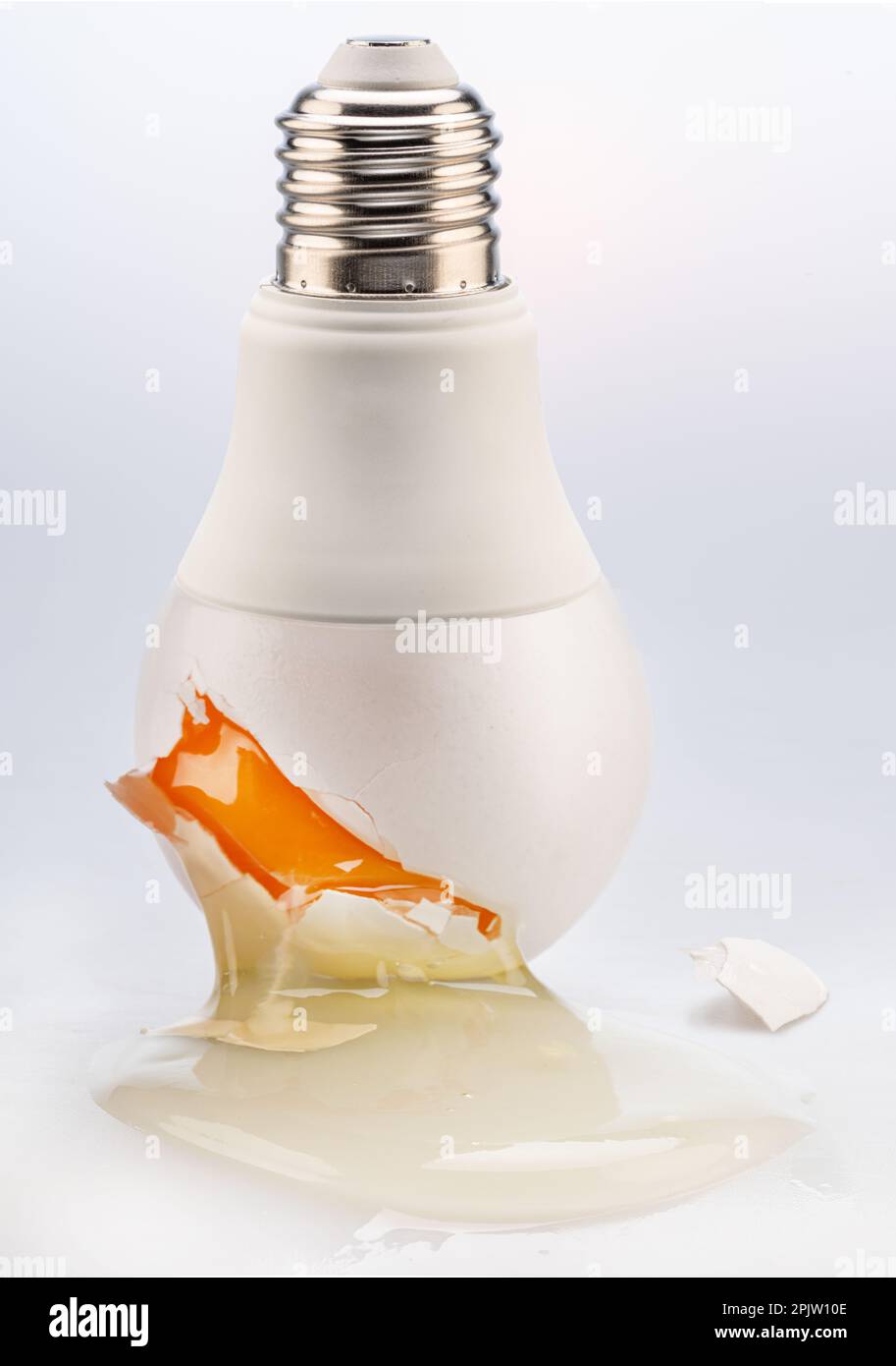 Egg yolk leaking from a light bulb crack conceptual picture Stock