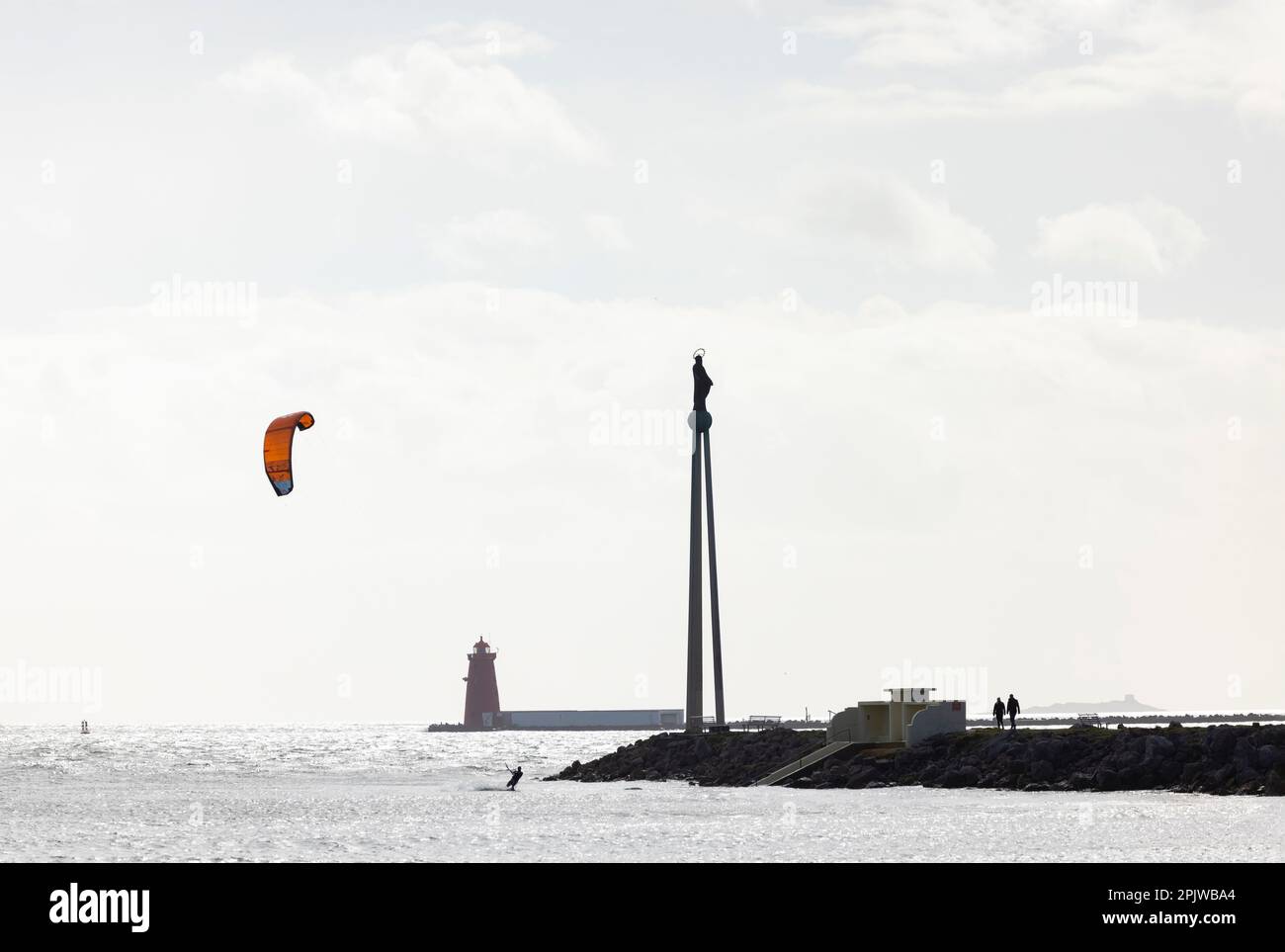 Dublin, Ireland. Silhouetted scene of Kite surfer riding waves at