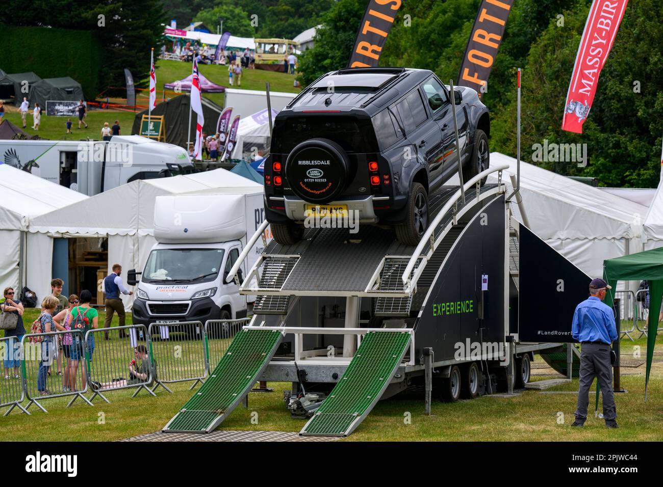 Defender drives up ascent (challenging temporary showground course) & visitors - L R Experience, Great Yorkshire Show 2022, Harrogate, England, UK. Stock Photo