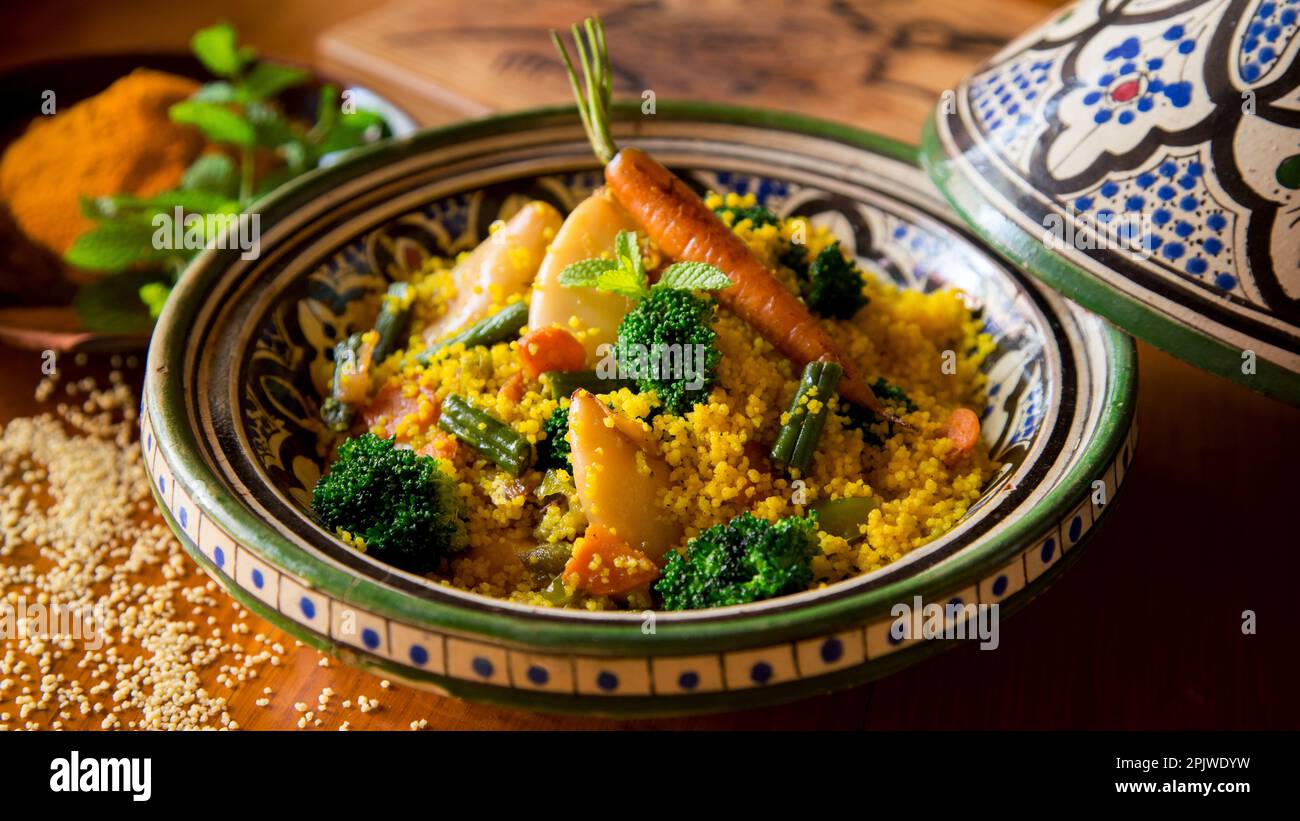 Colorful Moroccan tagine with curried cous cous with calamari, broccoli and other vegetables. Stock Photo
