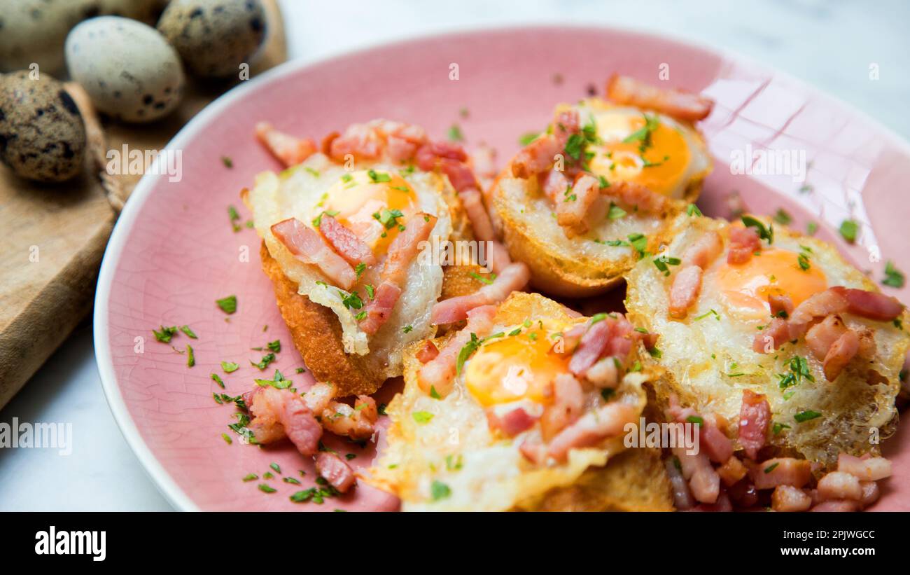 Toasts with fried quail eggs and bacon Stock Photo Alamy
