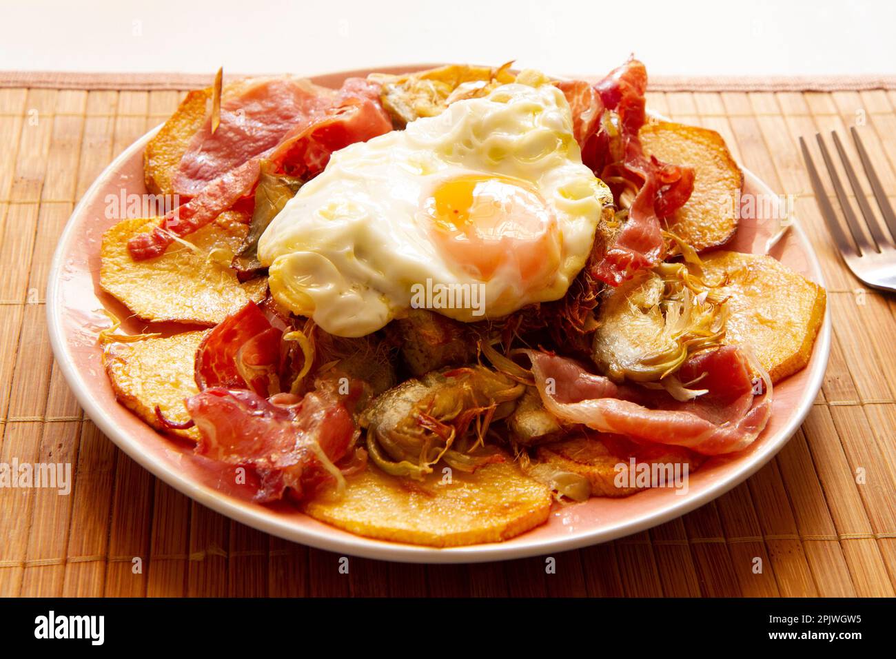 Fried eggs with chips and serrano ham. Traditional Spanish tapa