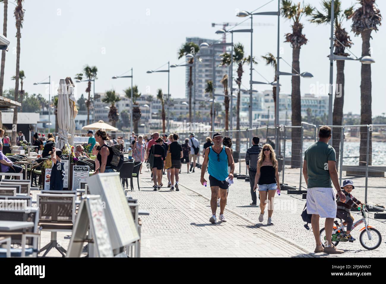 Tourists walk on the road next to the beach in Paphos, Cyprus, on Apr. 4, 2023. Cyprus sees massive increase in tourist arrivals in February with UK topping the list. Tourist arrivals in Cyprus increased by 65.6% year-on-year in February 2023. This fact, combined with the facts that Cyprus welcomed 3.2 million tourists last year, despite the absence of 800,000 Russian and Ukrainian tourists because of the war and that for 2022 it is estimated that tourists' spending has increased by about 13% on average for each trip, makes 2023 seem very promising. (Photo by Kostas Pikoulas/Sipa USA) Stock Photo