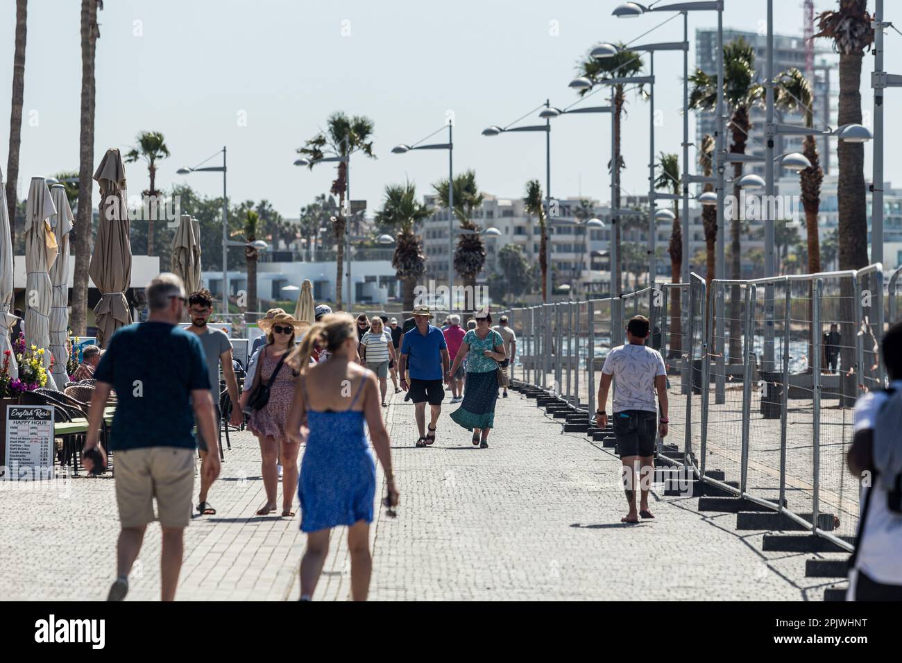 Tourists walk on the road next to the beach in Paphos, Cyprus, on Apr. 4, 2023. Cyprus sees massive increase in tourist arrivals in February with UK topping the list. Tourist arrivals in Cyprus increased by 65.6% year-on-year in February 2023. This fact, combined with the facts that Cyprus welcomed 3.2 million tourists last year, despite the absence of 800,000 Russian and Ukrainian tourists because of the war and that for 2022 it is estimated that tourists' spending has increased by about 13% on average for each trip, makes 2023 seem very promising. (Photo by Kostas Pikoulas/Sipa USA) Stock Photo