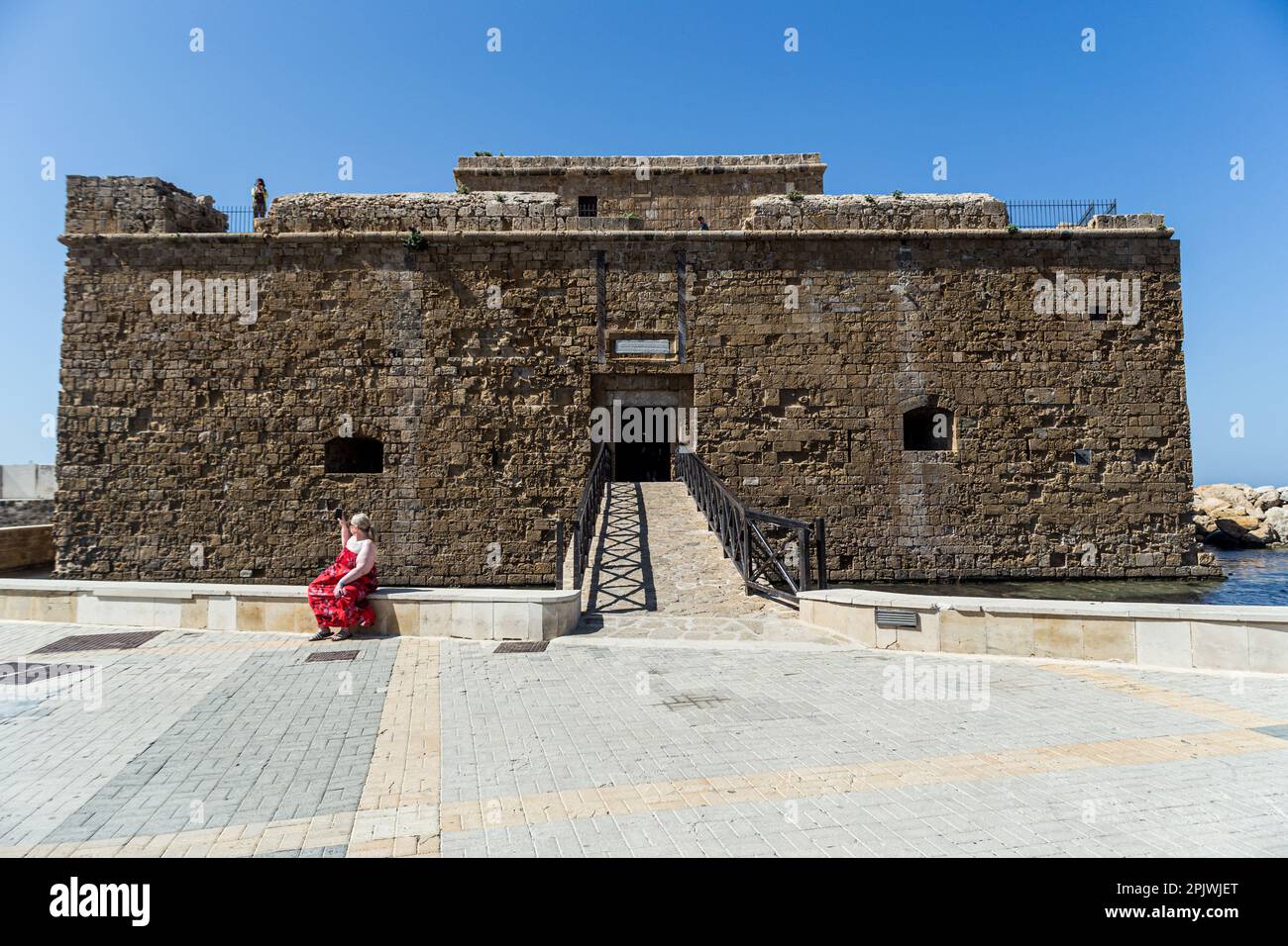 April 4, 2023, Paphos, Paphos, Cyprus: A tourist captures the area with her cell phone in front of the old castle in Paphos. Cyprus sees massive increase in tourist arrivals in February with UK topping the list. Tourist arrivals in Cyprus increased by 65.6% year-on-year in February 2023. This fact, combined with the facts that Cyprus welcomed 3.2 million tourists last year, despite the absence of 800,000 Russian and Ukrainian tourists because of the war and that for 2022 it is estimated that tourists' spending has increased by about 13% on average for each trip, makes 2023 seem very promising. Stock Photo