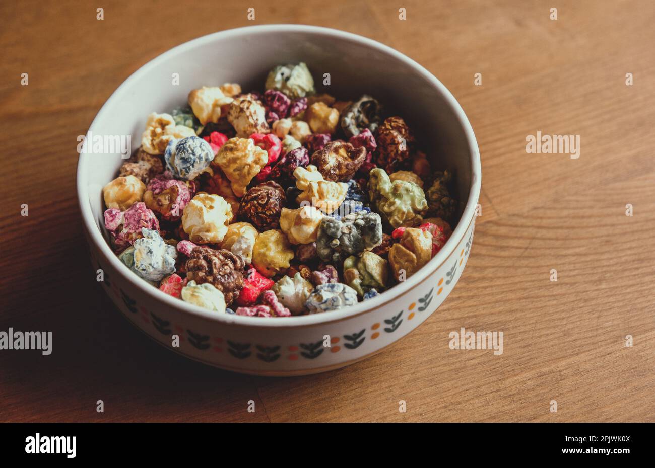 Multicolored kettle popcorn on wooden background. Soft focus Stock Photo