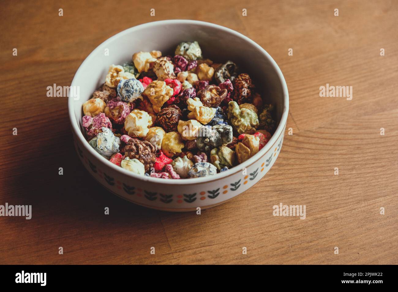 Multicolored kettle popcorn on wooden background. Soft focus Stock Photo