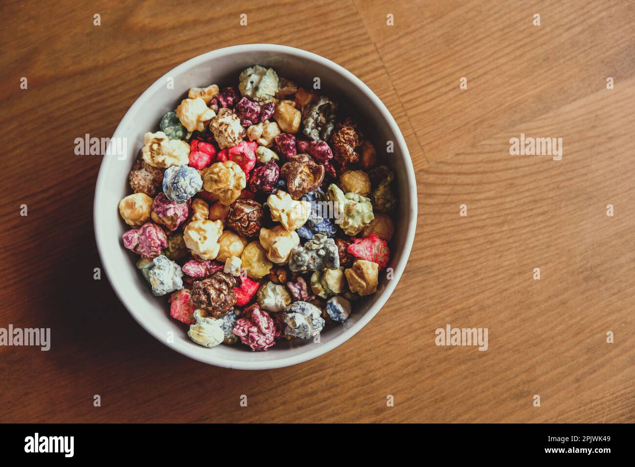 Multicolored kettle popcorn on wooden background. Soft focus Stock Photo