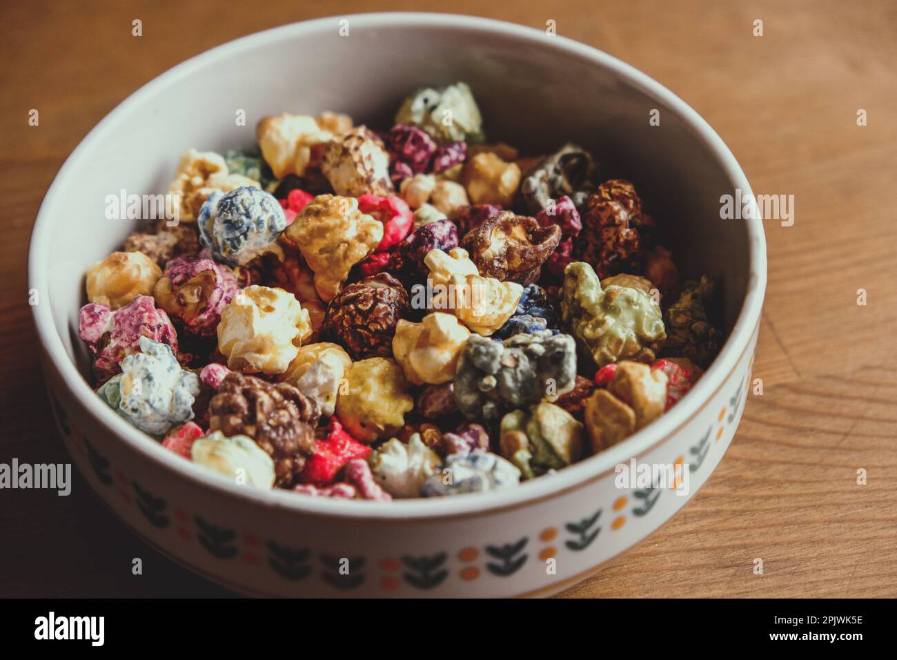 Multicolored kettle popcorn on wooden background. Soft focus Stock Photo