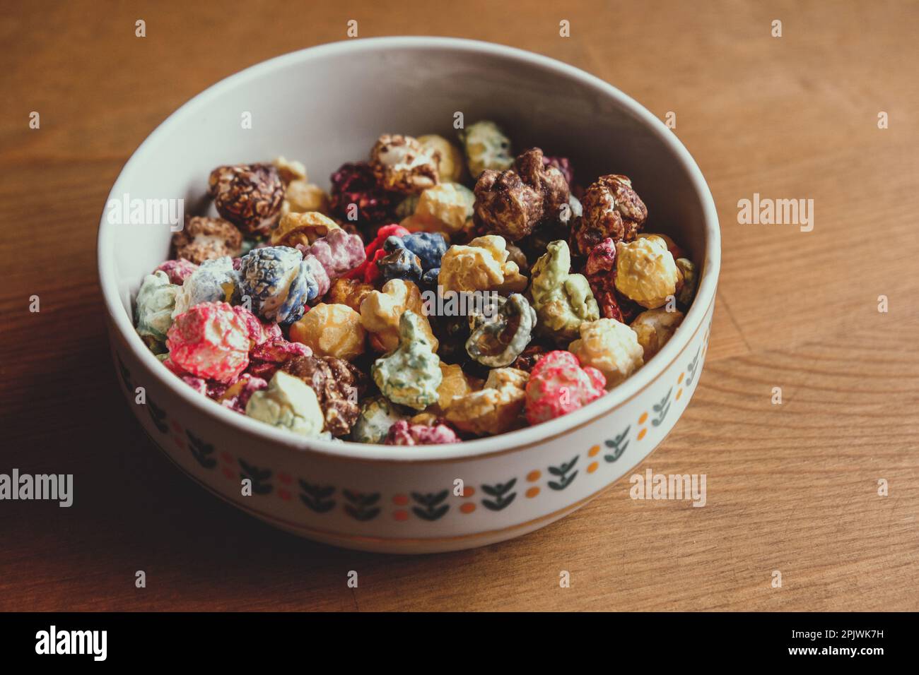 Multicolored kettle popcorn on wooden background. Soft focus Stock Photo