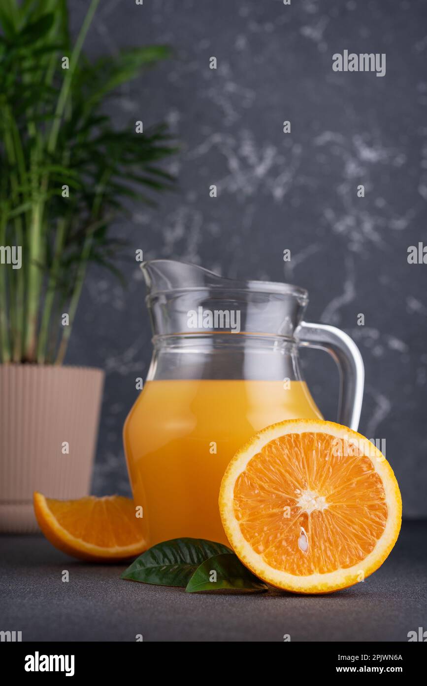 Glass jug of fresh orange juice with ripe orange fruits Stock Photo