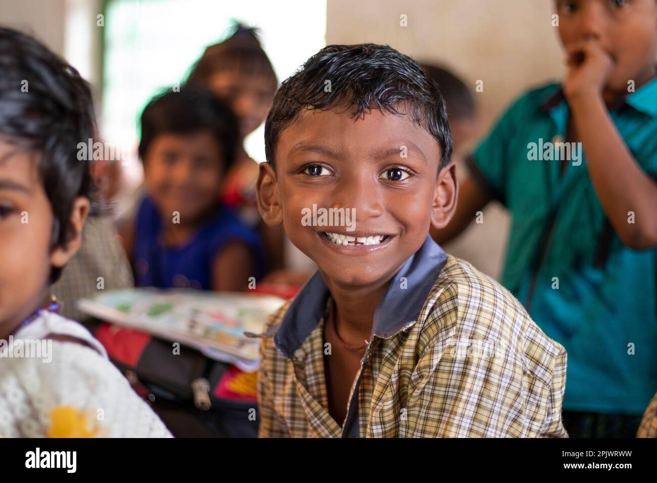 Happy school boy looking at camera in classroom Stock Photo