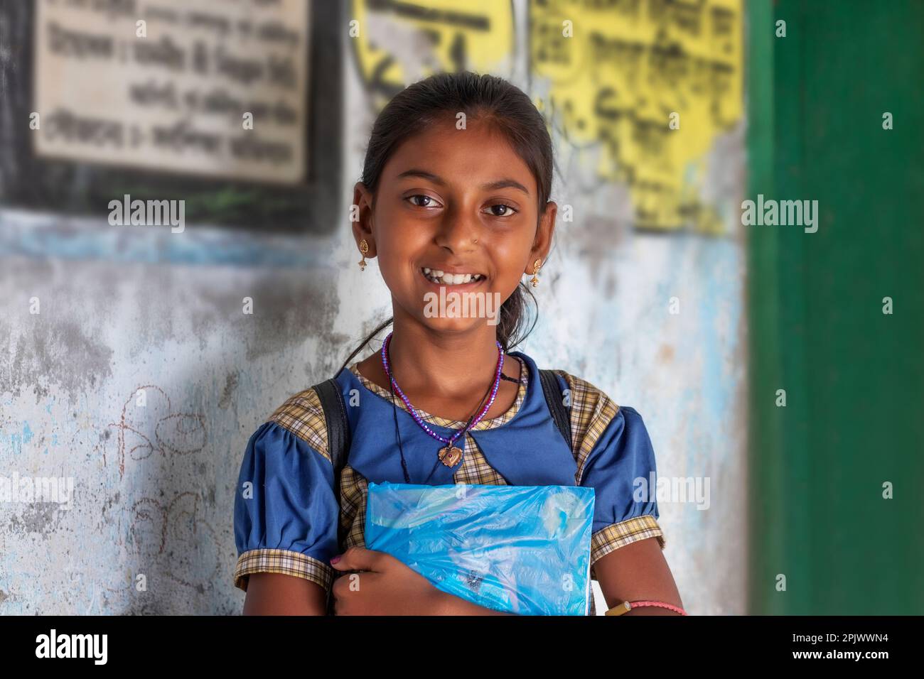 School Girl holding books standing at school Stock Photo - Alamy