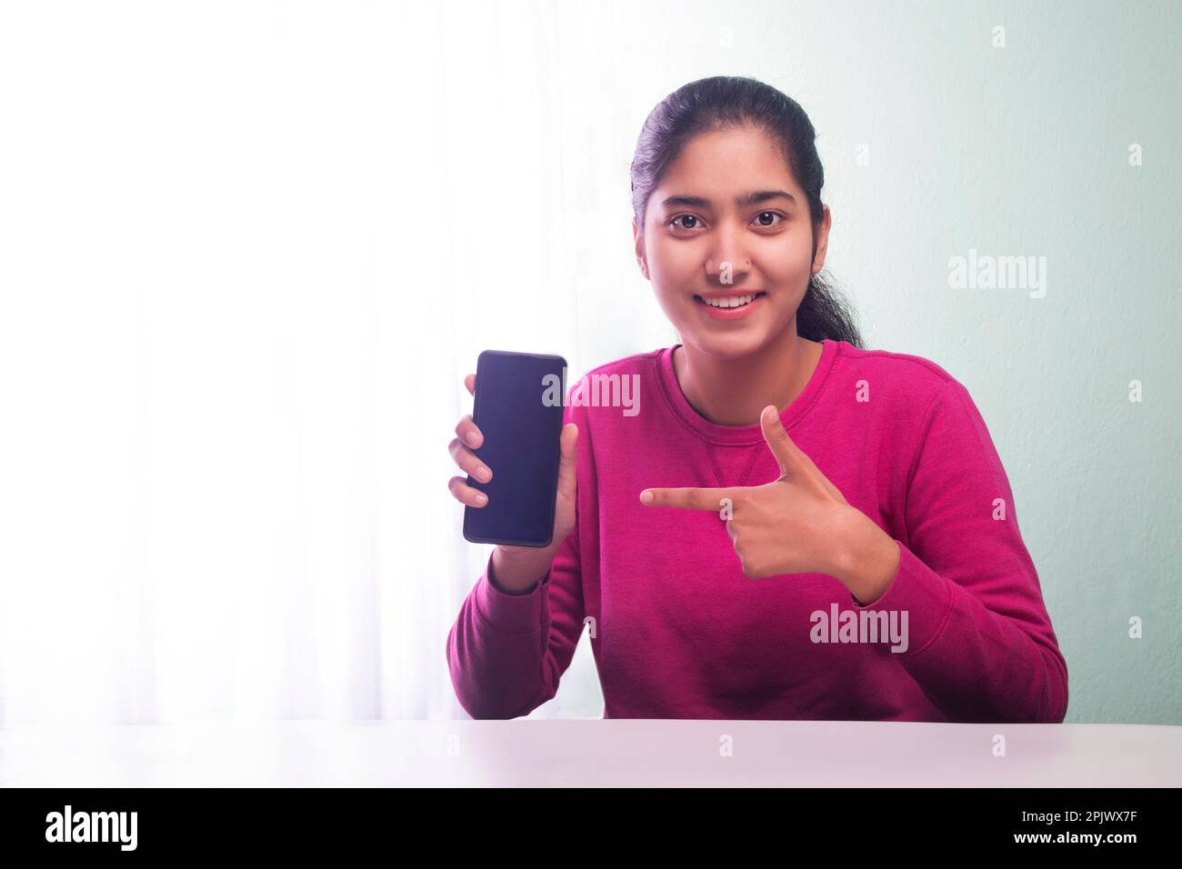 A HAPPY TEENAGER GIRL SHOWING MOBILE PHONE Stock Photo