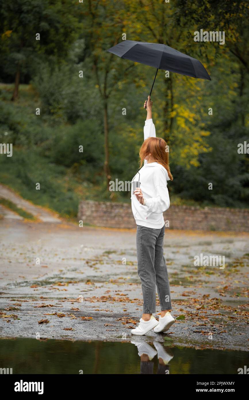 Girl with an umbrella in rainy weather in a city park Stock Photo - Alamy