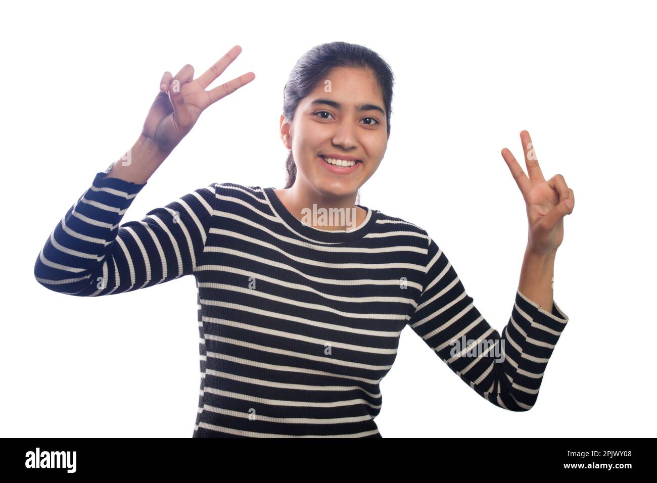 Portrait of happy young woman showing victory sign Stock Photo