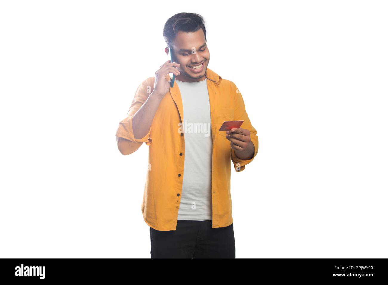 Young man talking mobile phone and holding a credit card Stock Photo