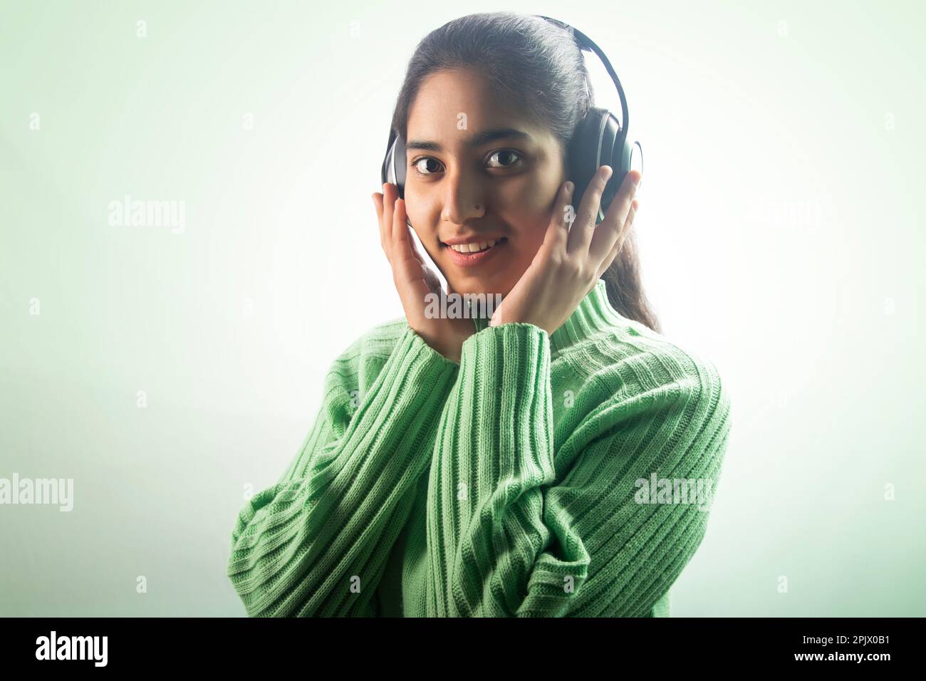 Portrait of a happy young woman listening music on headphones Stock Photo