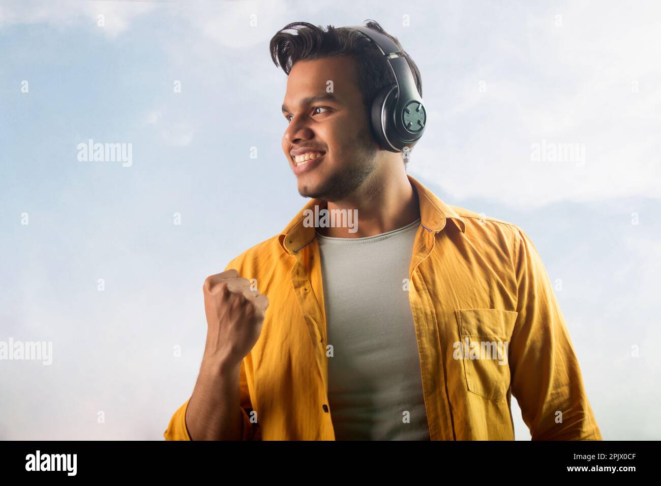 Portrait of a happy young man listening music on headphones Stock Photo