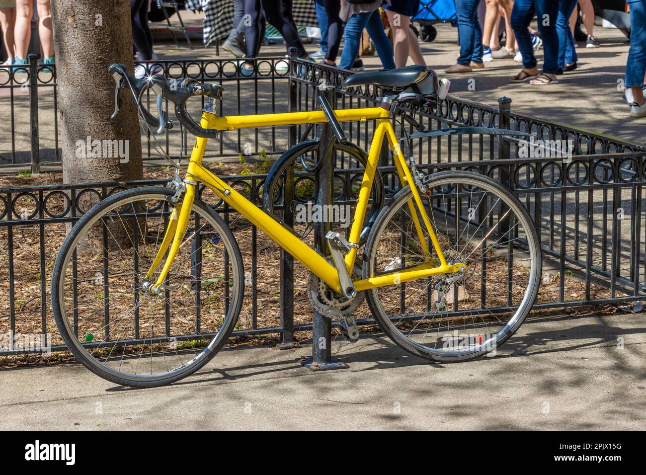 Yellow bike chained to a steel post in downtown district of Knoxville, TN. Stock Photo