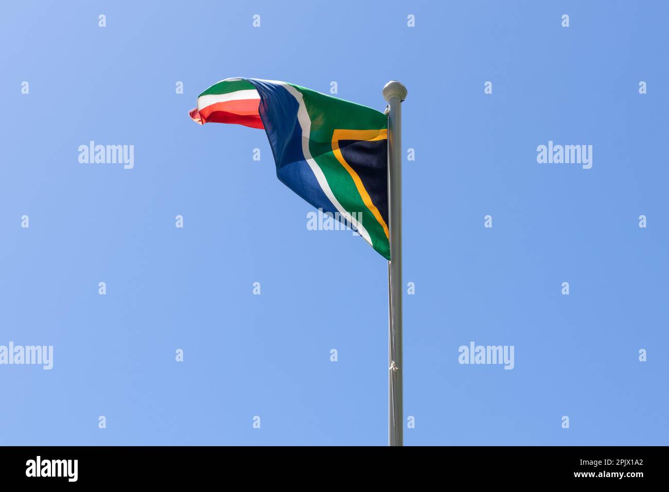 Flag of South Africa waving in the wind against a blue sky background Stock Photo