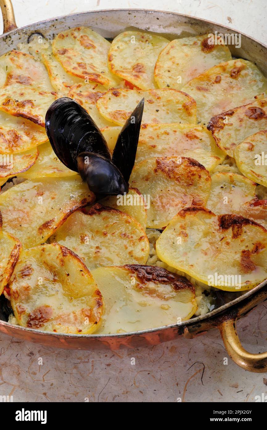 Rice, potatoes and mussels is a typical dish from the tradition of ...