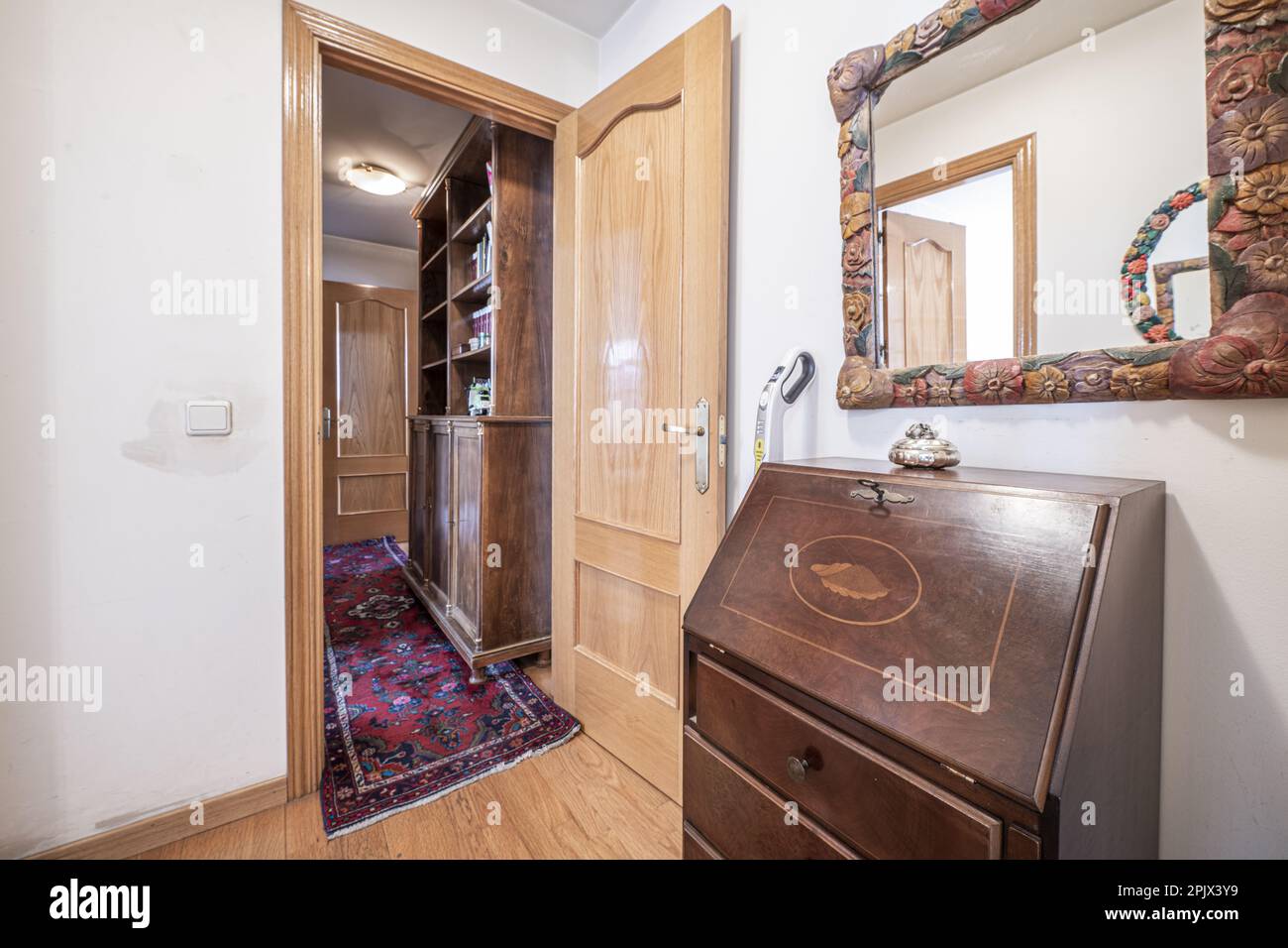 Entrance hall of a house with a mirror with a wooden frame with ...