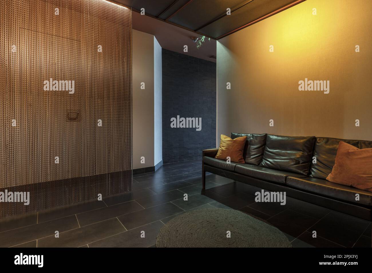 Lobby of a commercial premises with a white wall and a black wall in white and a long sofa with a modern design Stock Photo