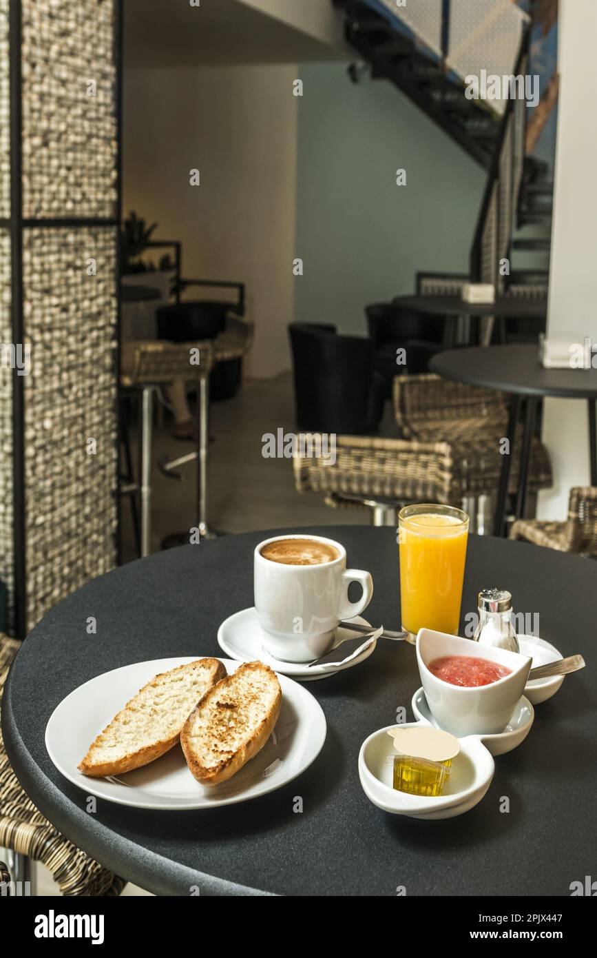 A Spanish breakfast with toasted loaf of bread with oil and tomato