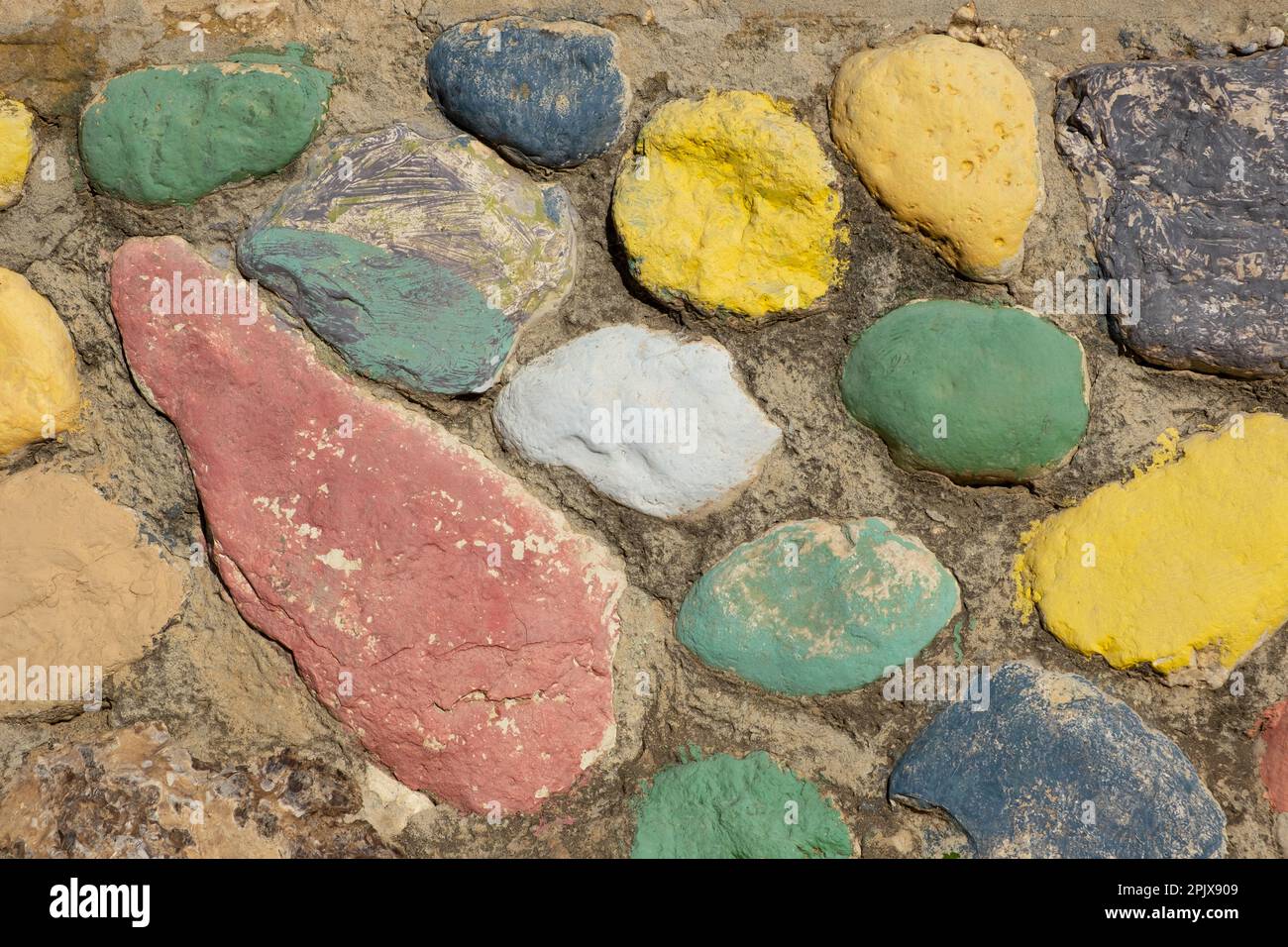 Various color painted flat stone retro garden decor Stock Photo - Alamy