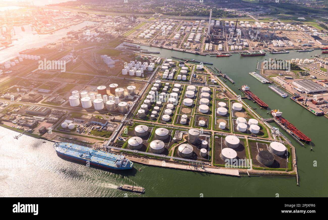 Aerial view of oil tankers and storage silo tanks at a petrochemical terminal port. Stock Photo