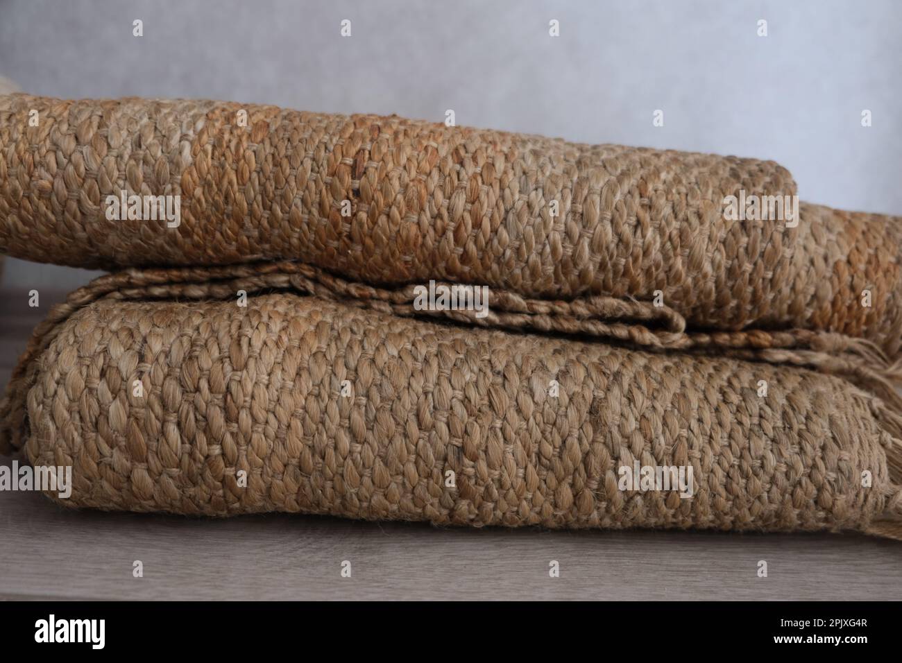 Folded jute carpet rug, front view of folded modern natural braided