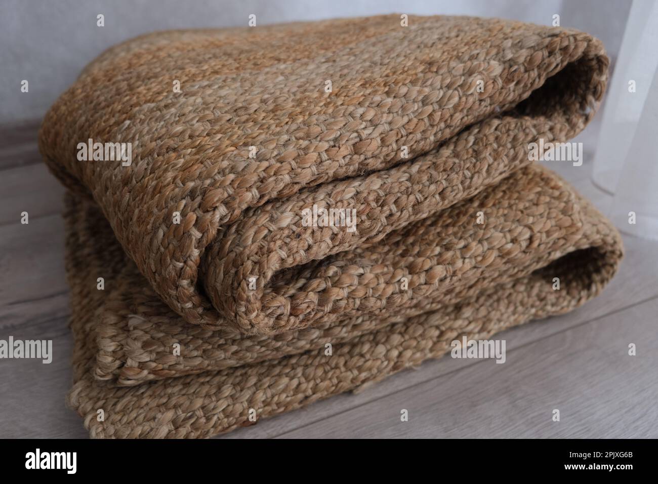 Folded jute carpet, folded modern natural braided jute carpet on the parquet in the bedroom