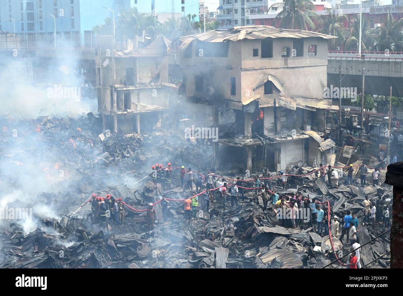 Firefighters try to extinguish a fire that broke out in a clothing ...