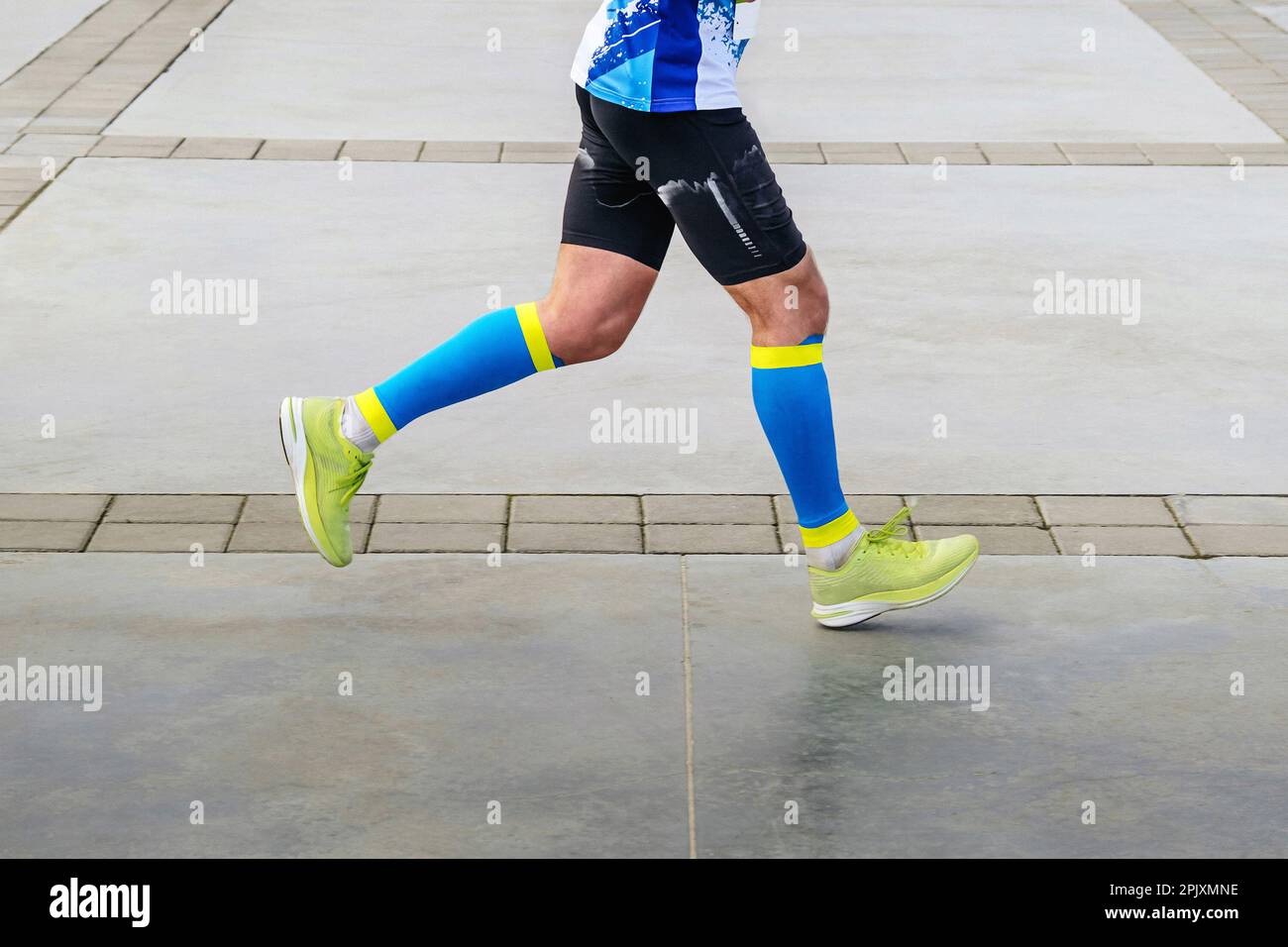 legs athlete runner in compression socks running marathon distance, bright and colorful sportswear Stock Photo