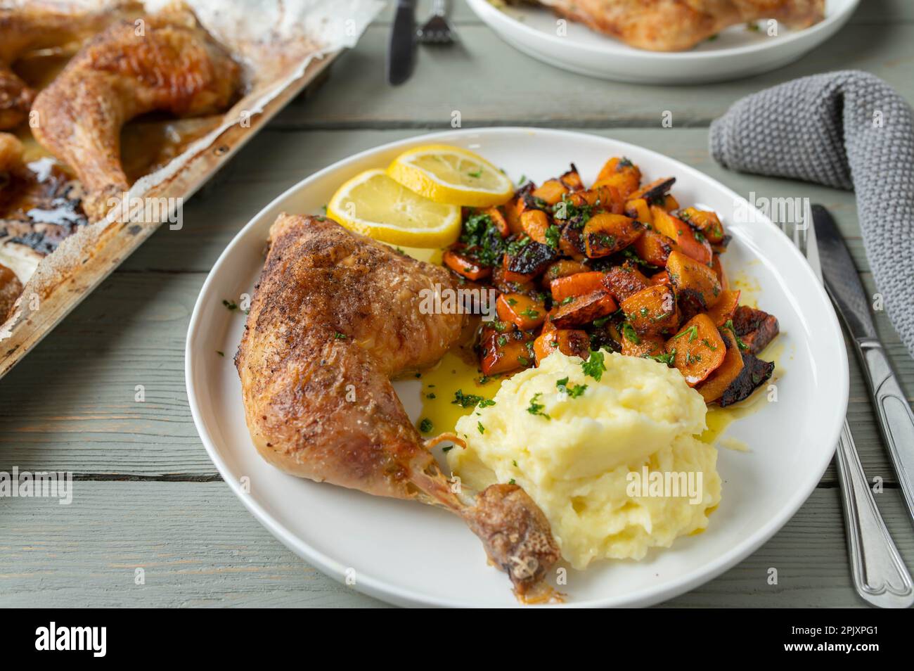 Oven baked chicken leg with marinated pumpkin salad and mashed potatoes on a plate Stock Photo