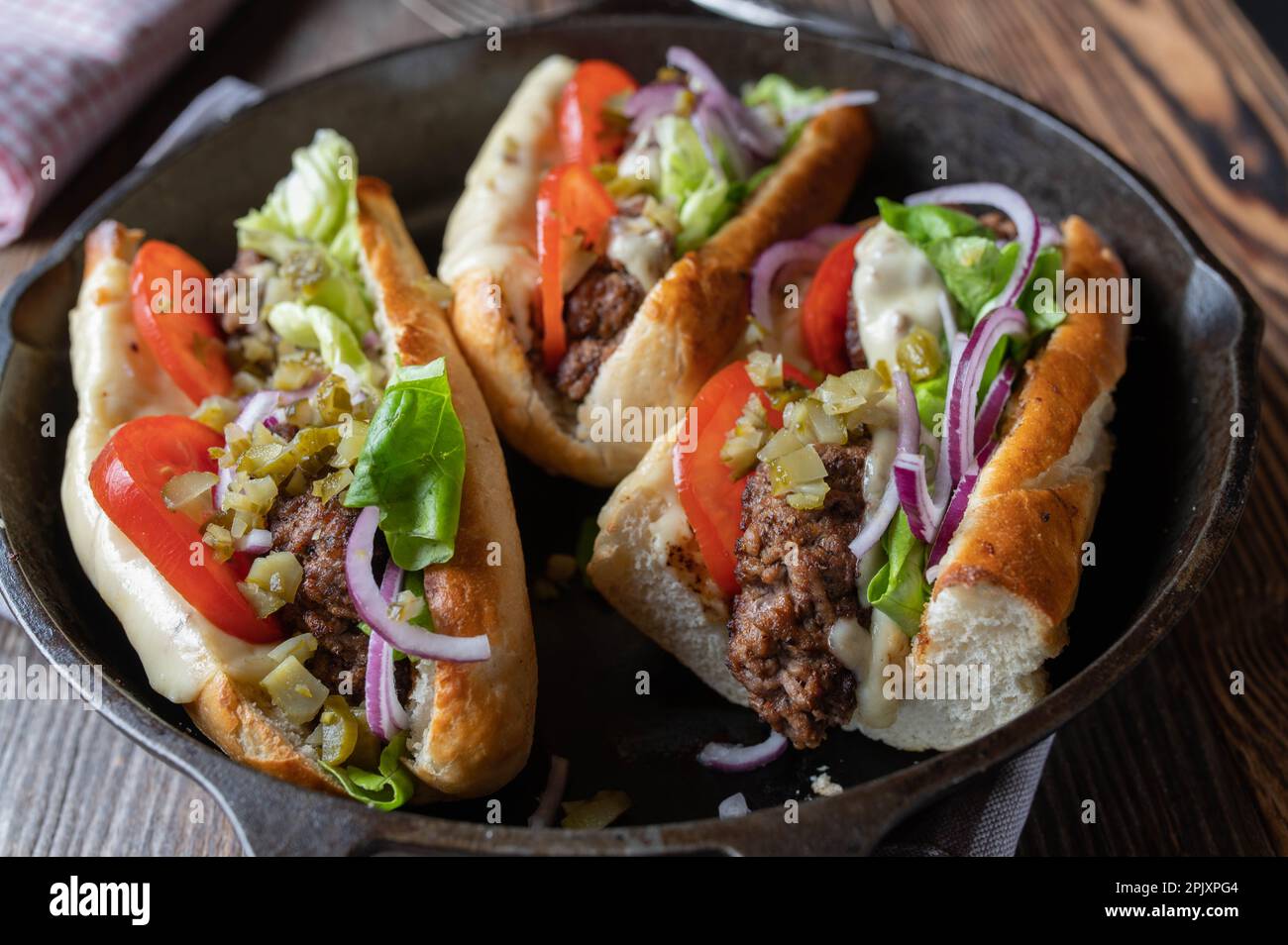 Beef Meatball sandwich with cheese, tomatoes, pickles, red onions, and lettuce on toasted baguette bread Stock Photo
