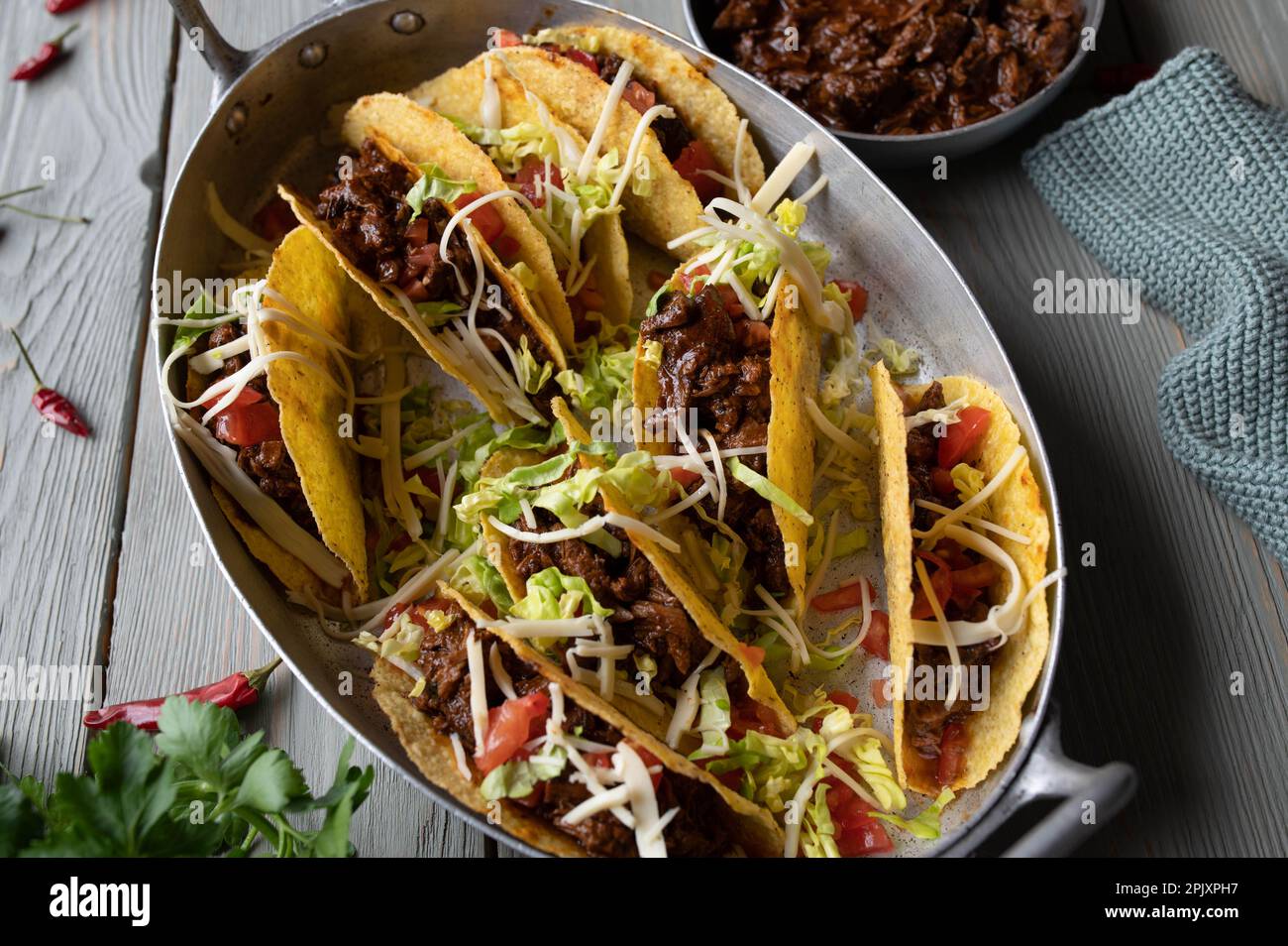 Tacos with slow cooked beef, cheese, tomatoes and lettuce in a old