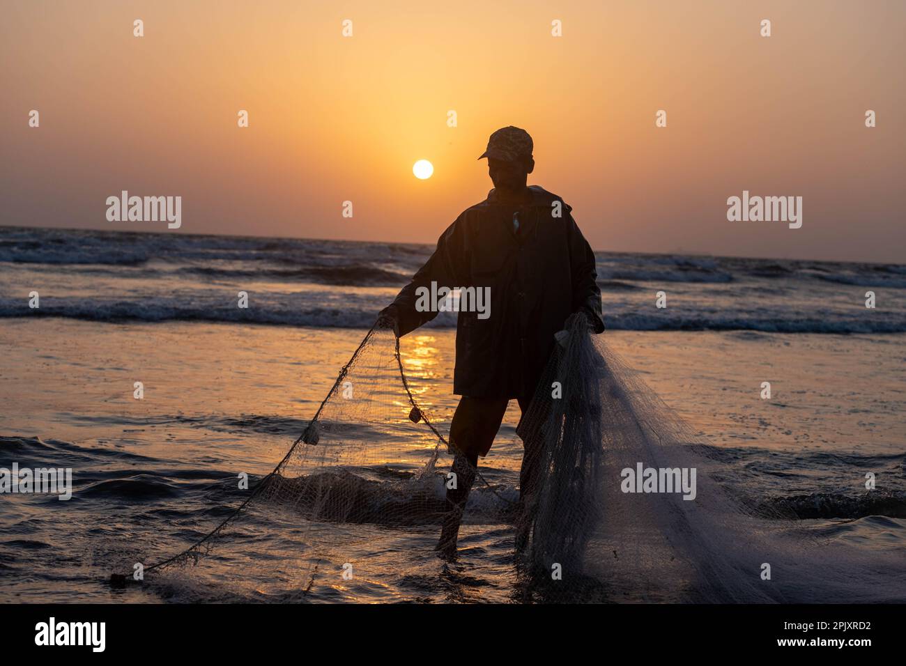 karachi pakistan 2021, a fisherman pulling fishing net to catch fish