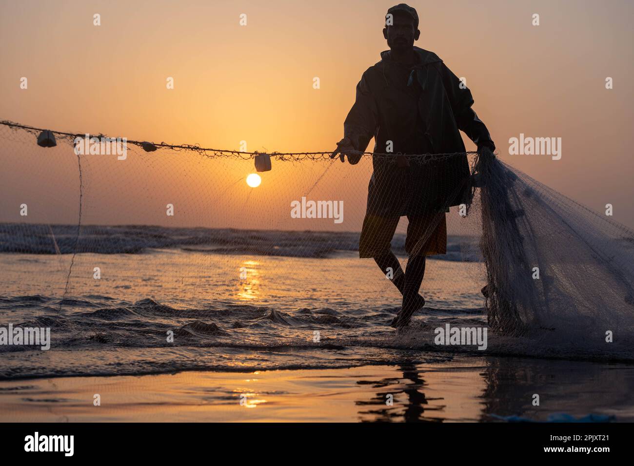 karachi pakistan 2021, a fisherman pulling fishing net to catch fish