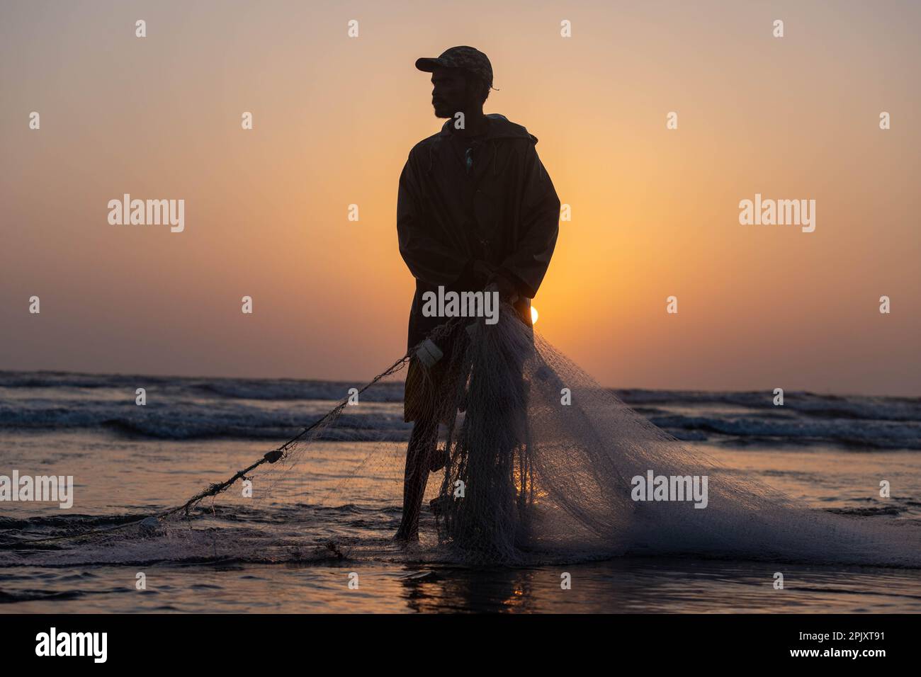 karachi pakistan 2021, a fisherman pulling fishing net to catch fish